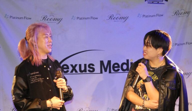 Nexus Mediaのステージでマイクを持ちトークする森宣博と前田健人